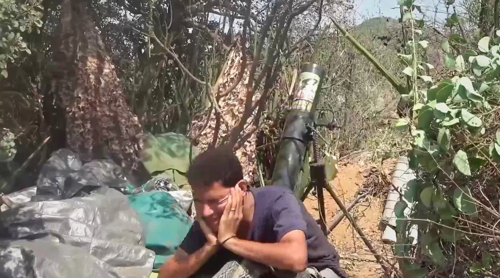 عنصر حوثي يغلق أذنيه خلال إطلاقه قذيفة هاون حيث تكثف الجماعة هجماتها على جبهات تعز (أ.ب)