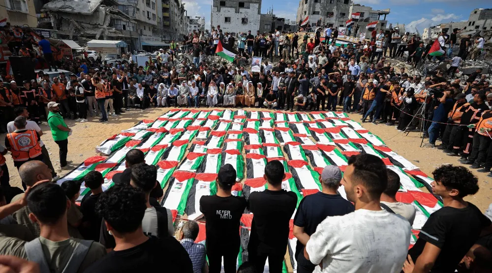 مشيّعون يحضرون جنازة جماعية لفلسطينيين انتُشلت جثامينهم من تحت أنقاض مبنى سكني تعرّض لضربة إسرائيلية في أكتوبر 2023 وفقاً للدفاع المدني بمدينة غزة (رويترز)