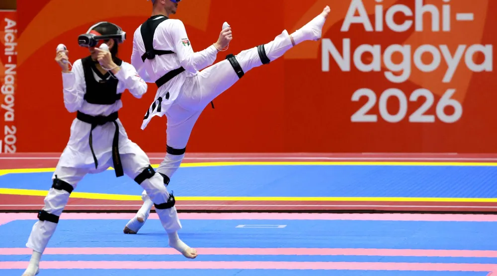 Kazakhstan's Rita Bakisheva (L) competes against Jordan's Mohammad Aladarbi in the mixed individual virtual taekwondo competition during the 2026 Asian Games at the Toyohashi Gymnasium in Toyohashi on October 2, 2026. (Photo by DAVID GRAY / AFP)