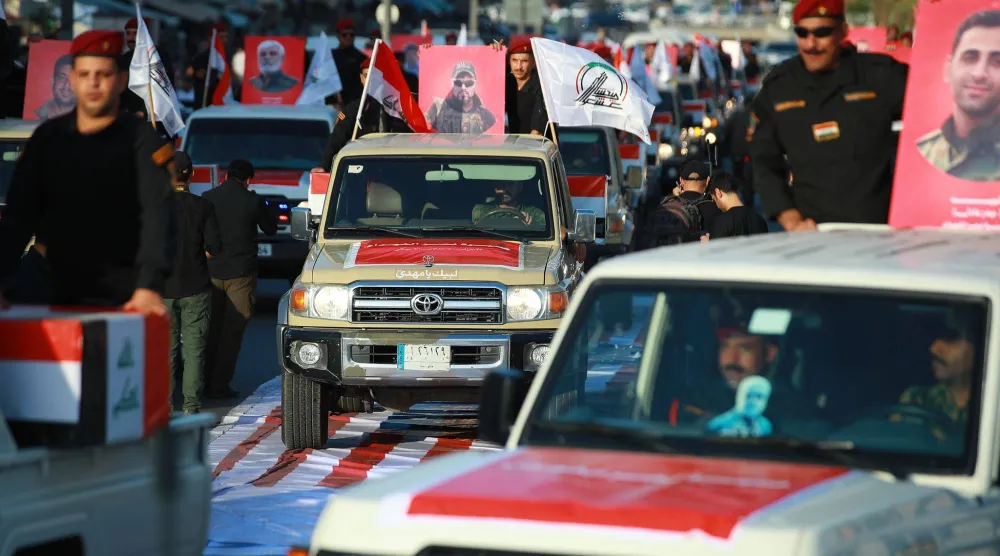 عناصر من قوات «الحشد الشعبي» العراقية في موكب بساحة التحرير في بغداد بمناسبة انسحاب القوات الأميركية من العراق (د.ب.أ)