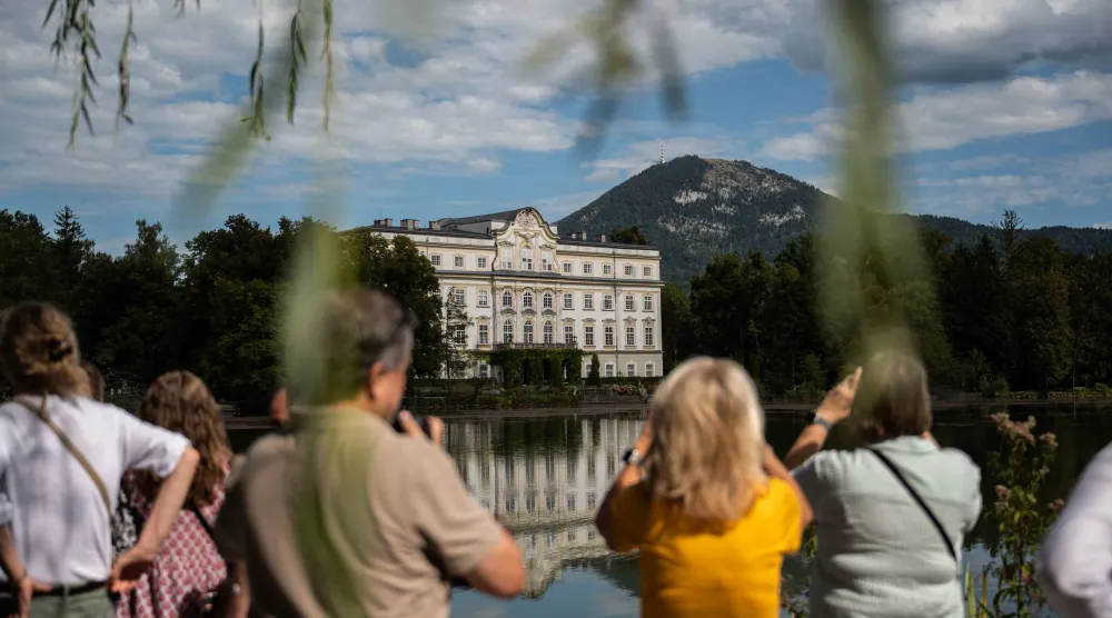 يلتقط زوارٌ صوراً لفندق «شلوس ليوبولدسكرون» (Schloss Leopoldskron) في سالزبورغ بالنمسا والذي استُخدم مقراً لإقامة عائلة «فون تراب» بفيلم «صوت الموسيقى» (The Sound of Music) (إسكندر خليف - نيويورك تايمز)