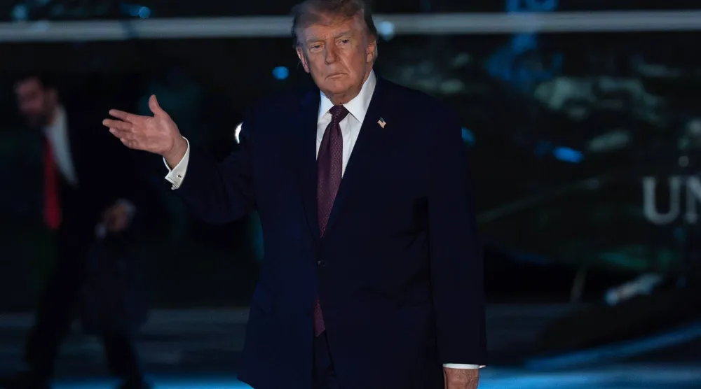 الرئيس الأميركي دونالد ترمب يلوح بيده للصحافيين لدى وصوله إلى البيت الأبيض في واشنطن، الجمعة (أ.ب)