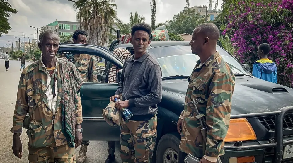 Etiyopya hükümetine bağlı Tigray Barış Gücü (TPF) mensupları, federal Etiyopya güçleri ve müttefiklerinin Tigray bölgesinin başkenti Mekele'ye girmesiyle eş zamanlı olarak sokaklarda devriye gezerken bir kamyonetin yanında toplanıyor (AFP)
