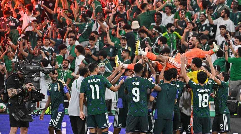 لاعبو المنتخب السعودي يحتفلون بالحارس العويس بطل ركلات الترجيح (تصوير: علي خمج)