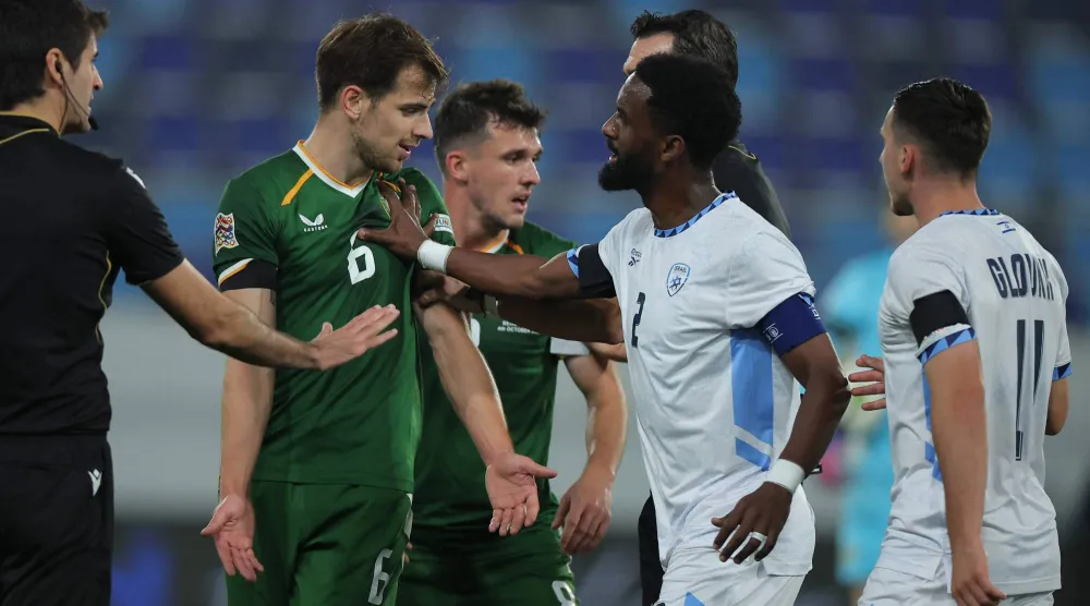 إيلي داسا لاعب إسرائيل يدفع جيسون مولومبي لاعب آيرلندا خلال مواجهة المنتخبين (أ.ف.ب)