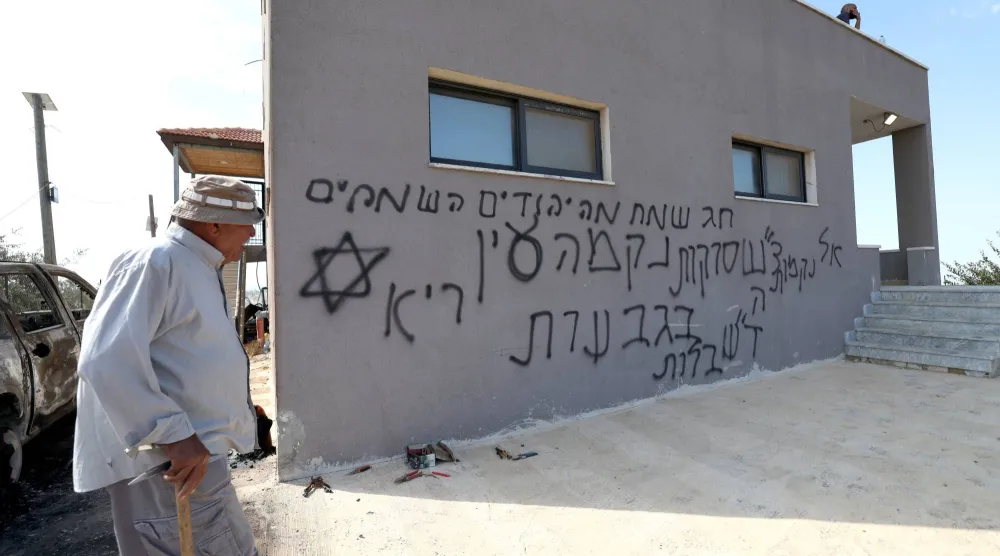 فلسطيني أمام منزل اعتدى عليه مستوطنون إسرائيليون قرب رام الله بالضفة الغربية 28 سبتمبر الماضي (إ.ب.أ)