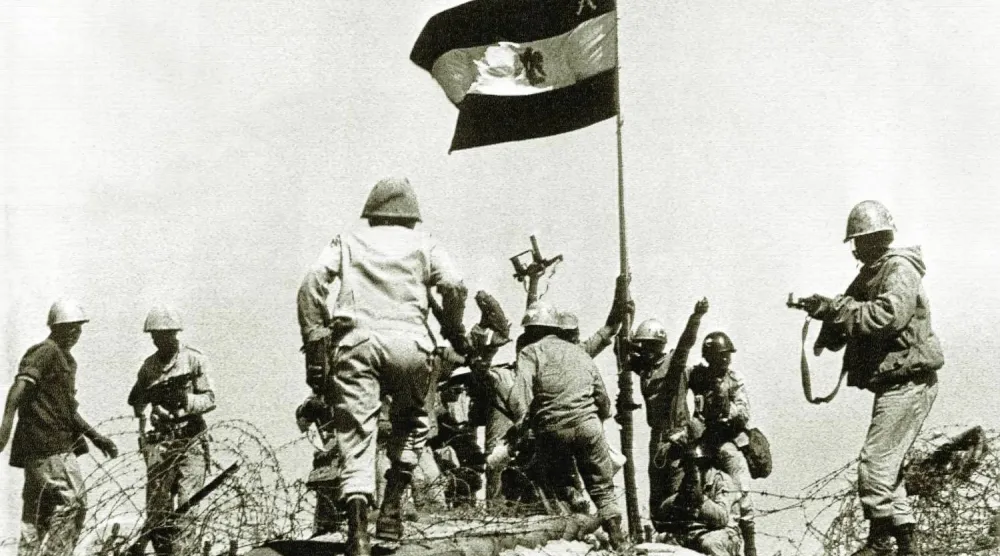 جنود مصريون يرفعون العلم على الضفة الشرقية من قناة السويس خلال معارك حرب أكتوبر 1973 (أ.ب)