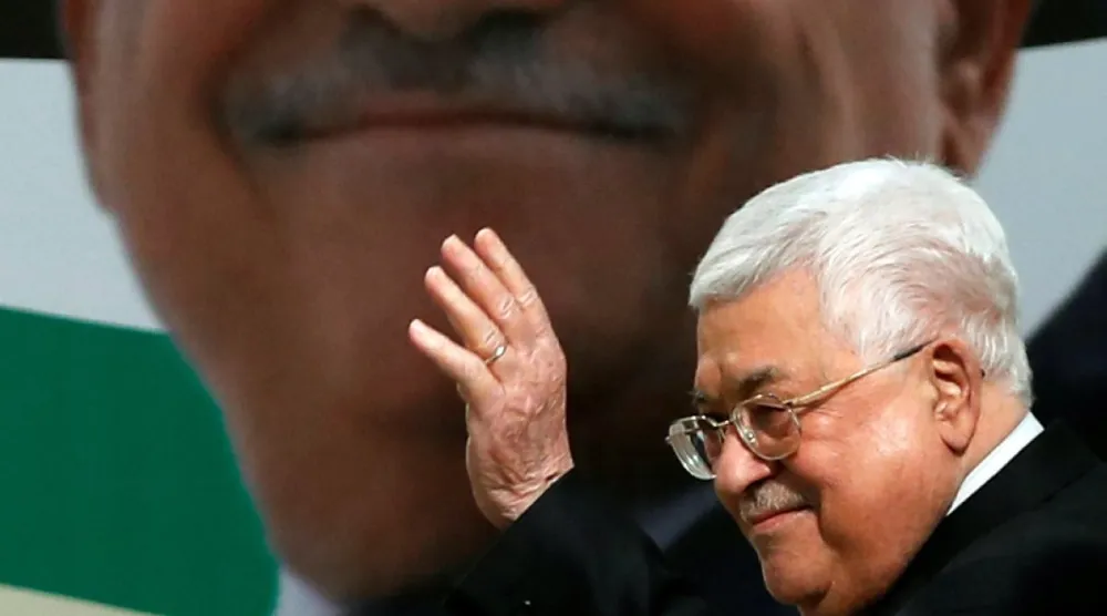 الرئيس الفلسطيني محمود عباس يلوح بيده خلال مراسم إحياء الذكرى الخامسة والخمسين لتأسيس حركة فتح في رام الله بالضفة الغربية عام 2019 (رويترز)
