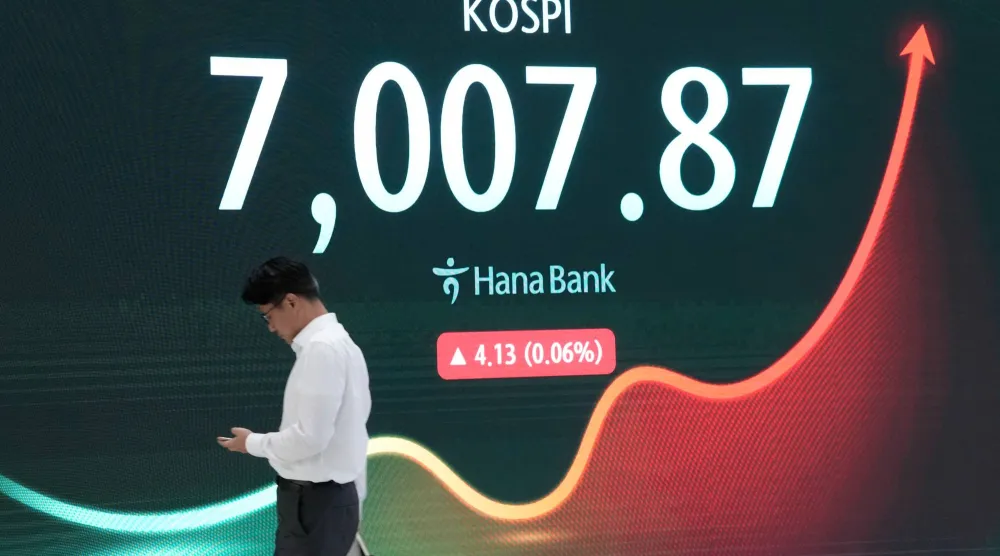 متداول يمر أمام شاشة تعرض مؤشر «كوسبي» في غرفة تداول العملات الأجنبية في المقر الرئيسي لبنك هانا في سيول يوم الثلاثاء (أ.ب)