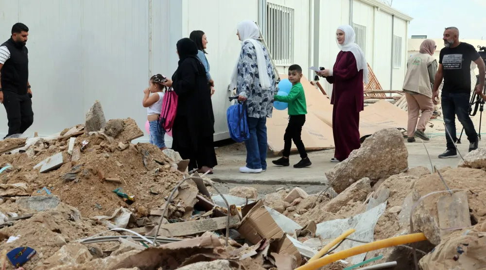 أطفال يغادرون برفقة ذويهم الفصول الدراسية المؤقتة في مدرسة «برج قلاوية» المتوسطة جنوب لبنان (إ.ب.أ)