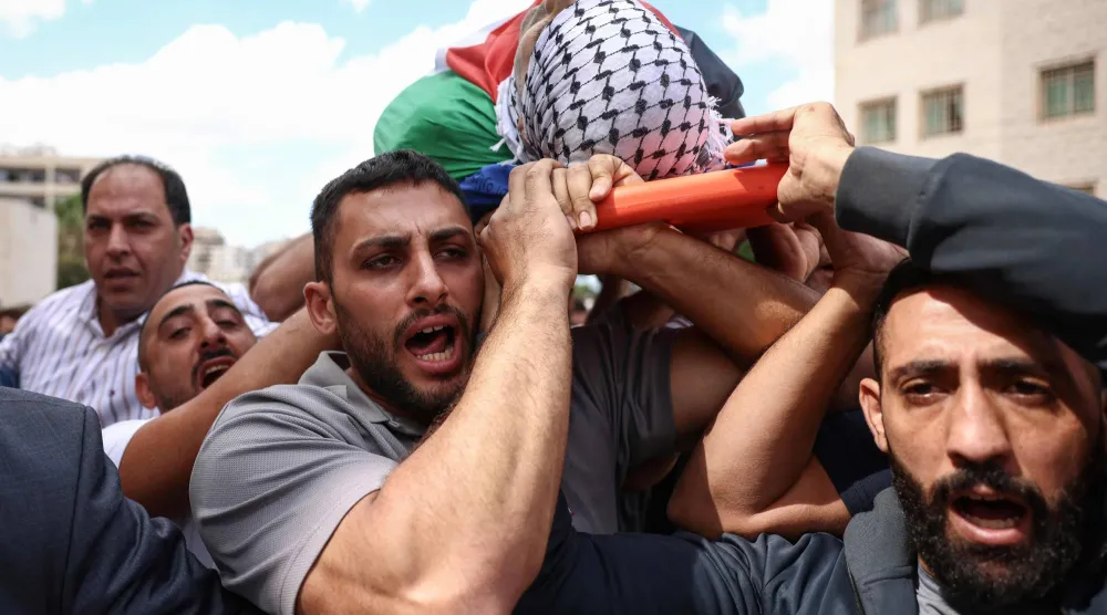 مشيعون يحملون جثمان الفلسطيني علي البزاري في مستشفى رفيديا بمدينة نابلس في الضفة الغربية (أ.ف.ب)