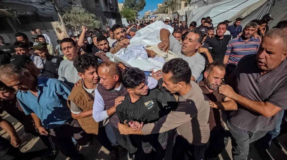 فلسطينيون يحضرون جنازة طفل ١٤ عاماً في مجمع ناصر الطبي بخان يونس بعد وفاته متأثراً بجراحه إثر إصابته برصاصة قالت عائلته إنها أُطلقت من الجانب الإسرائيلي قرب خيمتهم في وسط المدينة (د.ب.أ)