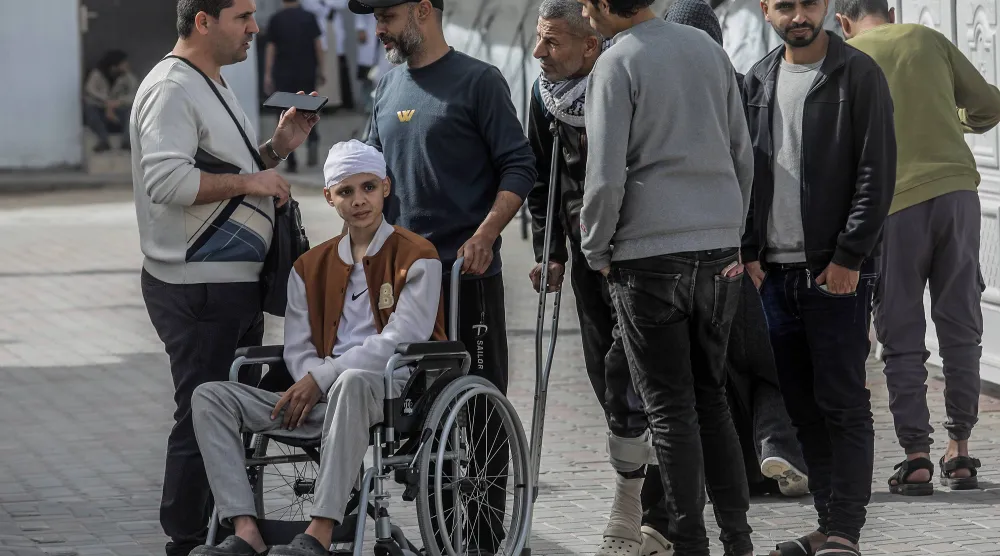 مرضى فلسطينيون ينتظرون في ساحة مستشفى الهلال الأحمر لإجلائهم من قطاع غزة عبر معبر رفح الحدودي مع مصر لتلقي العلاج في فبراير الماضي (د.ب.أ)