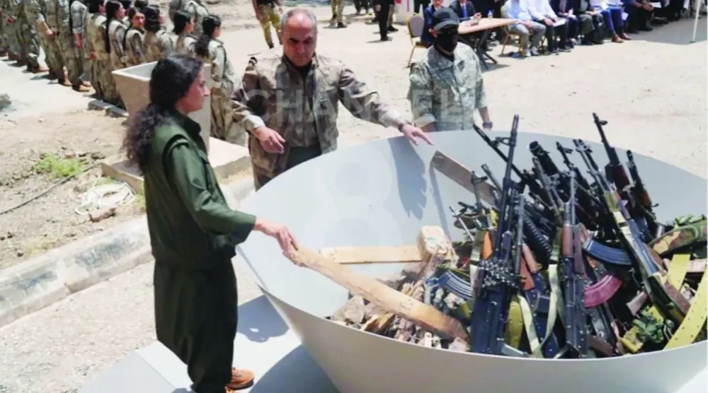 Kürdistan Topluluklar Birliği (KCK) Eş Başkanı Veysi Hozat, 11 Temmuz 2025’te Irak’ın kuzeyinde düzenlenen sembolik silah yakma töreninde, PKK’lı 30 militanın önünde yer aldı. (Reuters)
