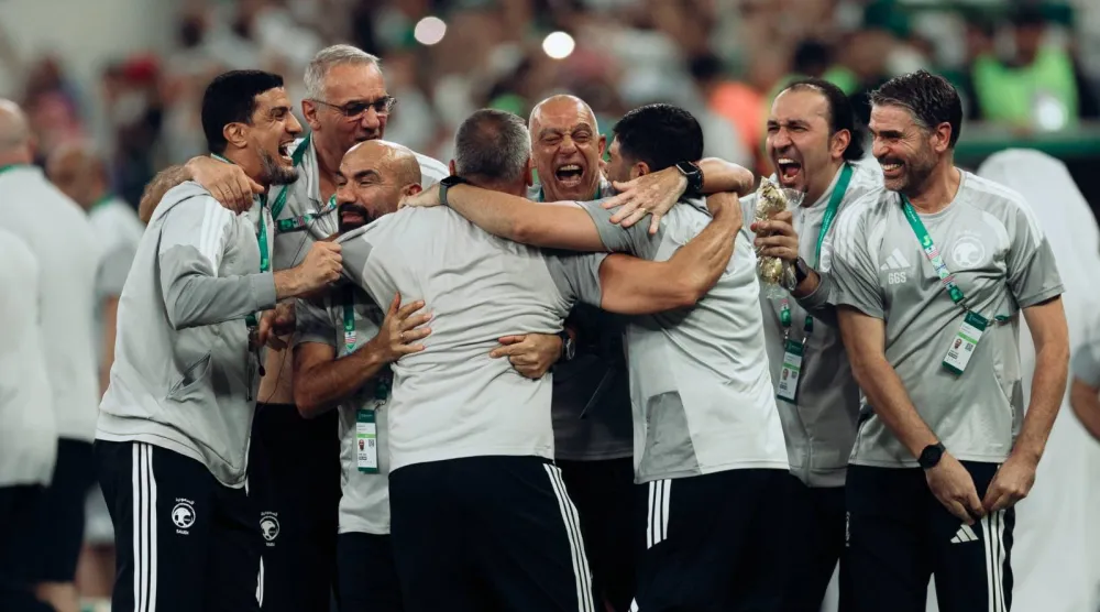 أعضاء الجهازين الفني والإداري للمنتخب يحتفلون باللقب (المنتخب السعودي)