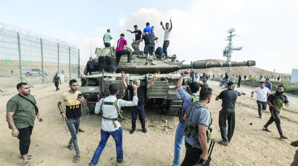 فلسطينيون في خان يونس يعتلون مركبة عسكرية إسرائيلية تم الاستيلاء عليها ضمن عملية «طوفان الأقصى» (د.ب.أ)