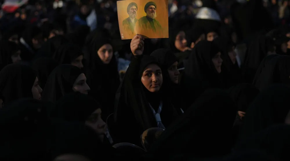 مناصرات لـ«حزب الله» يرفعن صورة لأمينيه العامين السابقين حسن نصر الله وهاشم صفي الدين في الذكرى الثانية لاغتيالهما في ضاحية بيروت الجنوبية (أ.ب)