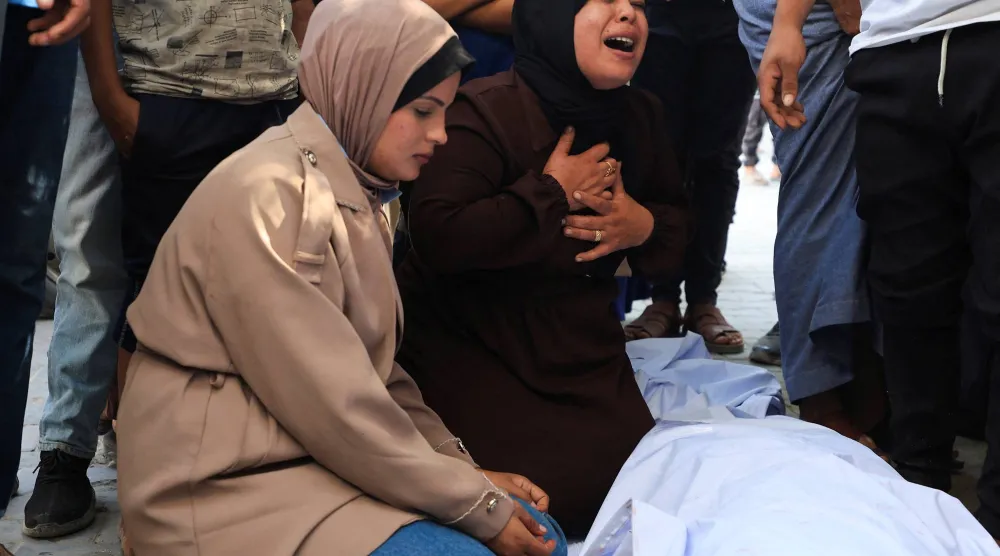 أشخاص يشاركون في مراسم تأبين فلسطينيين قُتلوا في غارة جوية إسرائيلية وفقاً لمسعفين في مدينة غزة (رويترز)
