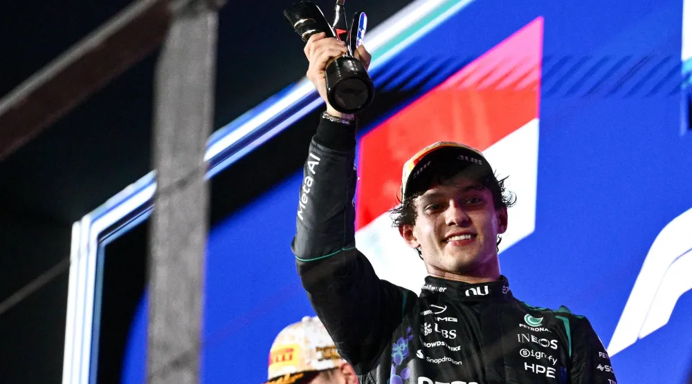 Third-placed Mercedes' Italian driver Kimi Antonelli lifts his trophy as he celebrates on the podium after the Formula One Singapore Grand Prix at the Marina Bay Street Circuit in Singapore on October 11, 2026. (AFP) 