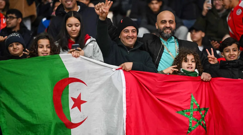 جماهير ترفع العلمين المغربي والجزائري (أ.ف.ب)