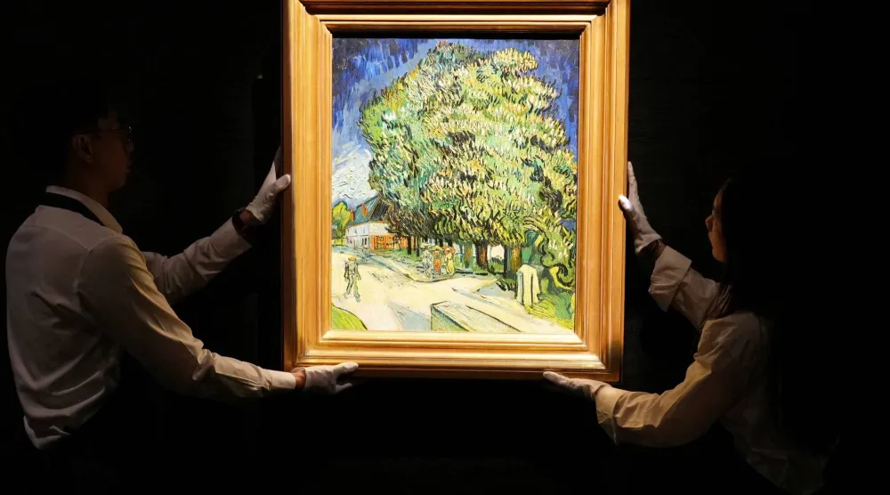 Staff members pose with Vincent van Gogh's "Chataigniers en fleurs" (Chestnut Trees in Blossom) at a media preview ahead of its auction in New York, at Sotheby's in Hong Kong, China, October 13, 2026. REUTERS/Joyce Zhou