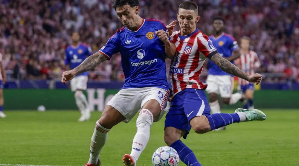 Manchester United's Argentine defender Lisandro Martinez (L) challenges for the ball against Atletico Madrid's Spanish defender Alejandro Grimaldo during the UEFA Champions League soccer match between Atletico Madrid and Manchester United, in Madrid, Spain, 13 October 2026. (EPA)