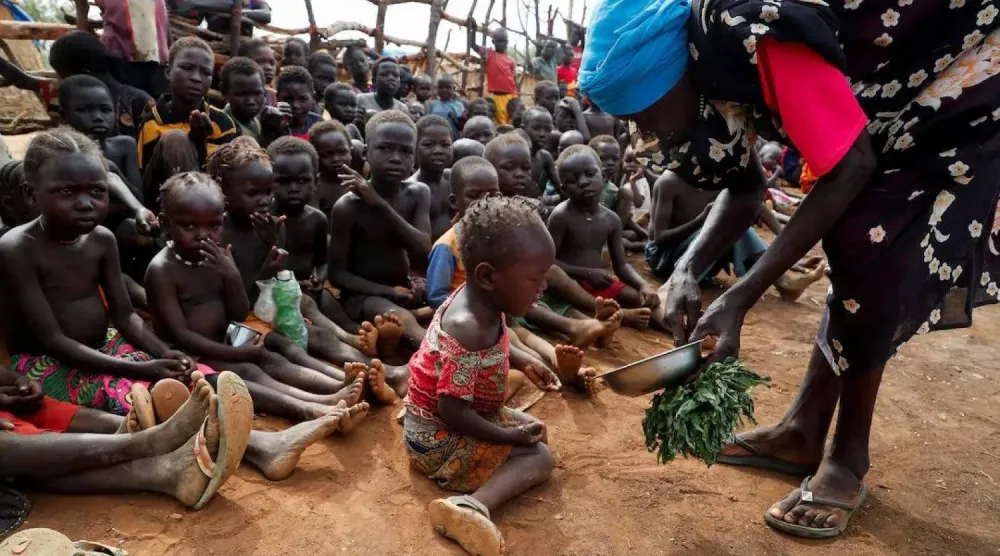 تقديم طعام للأطفال الأيتام في مخيم بروام للنازحين داخلياً بجنوب كردفان بالسودان 22 يونيو 2024 (رويترز)