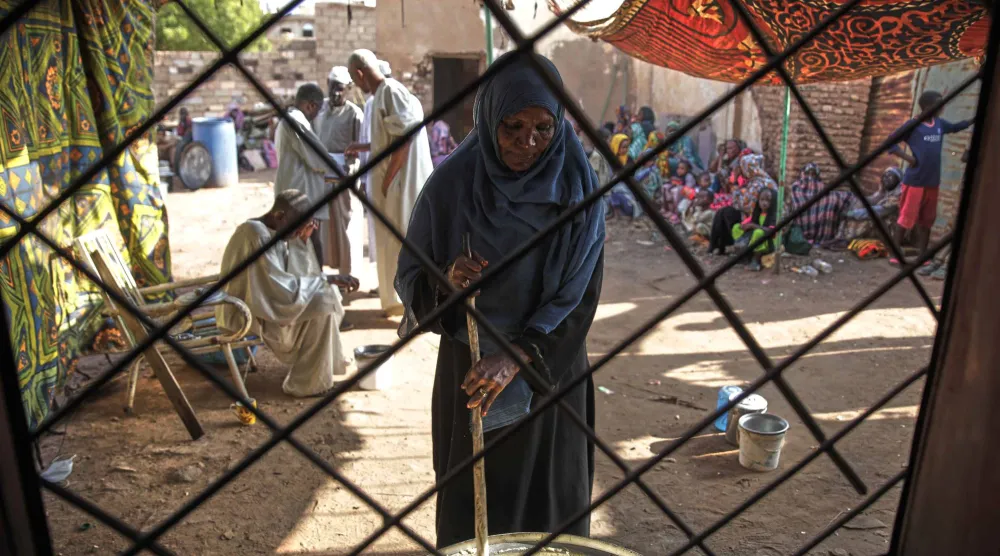 سودانية تعد طعاماً لتوزيعه بالخرطوم يوم 23 سبتمبر الماضي (أ.ب)