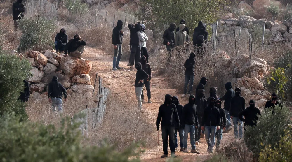 مستوطنون إسرائيليون يتجمّعون وسط اشتباكات مع الفلسطينيين خلال موسم قطف الزيتون في أبو فلاح بالقرب من رام الله بالضفة الغربية يوم 16 أكتوبر 2026 (رويترز)