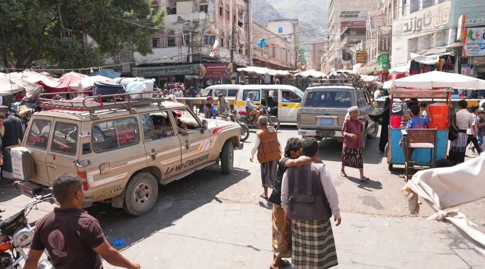 حشود من الناس في محطة للحافلات الصغيرة يستخدمها النازحون لمغادرة مدينة تعز (أ.ب)