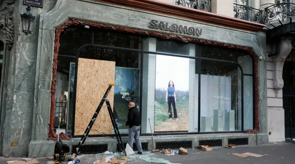 Paris’te hayat pahalılığı ve akaryakıt fiyatlarındaki artışı protesto eden ülke çapındaki gösterilerin ertesi günü çıkan çatışmalarda zarar gören Salomon mağazasının vitrinini onaran bir kişi (Reuters)