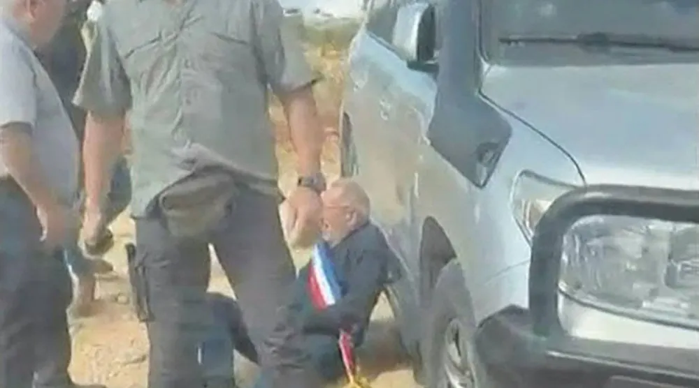 لقطة من مقطع فيديو يعود تاريخ نشره إلى يوم السبت يظهر رجلاً ملقى على الأرض ويُرجح أنه برنارد بودو رئيس بلدية أولنوي-أيميري شمال فرنسا الذي تعرض لهجوم من قبل مستوطنين إسرائيليين في بلدة الطيبة الفلسطينية بالضفة الغربية المحتلة (أ.ف.ب)