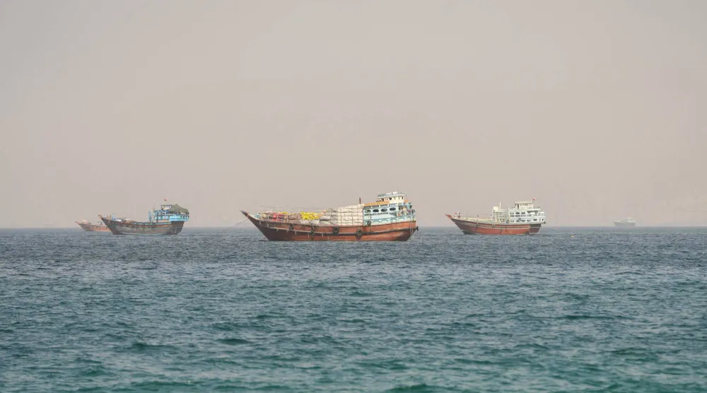 سفن تعبر مضيق هرمز كما تبدو من شبه جزيرة مسندم العُمانية يوم الاثنين (رويترز)