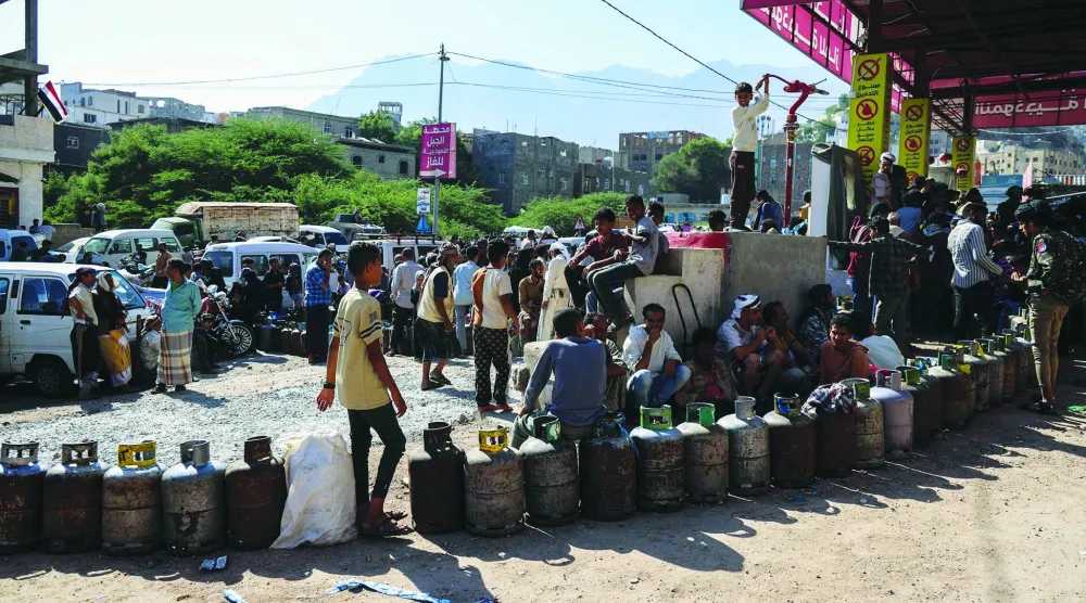 
يمنيون يصطفون لإعادة تعبئة أسطوانات الغاز في محطة بمدينة تعز أمس (أ.ف.ب)