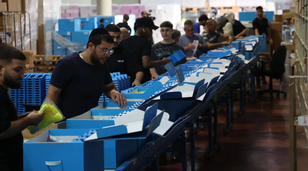 موظفون إسرائيليون يجهزون أوراق الاقتراع ومواد انتخابية أخرى في مركز انتخابي قرب تل أبيب الأسبوع الماضي (د.ب.أ)