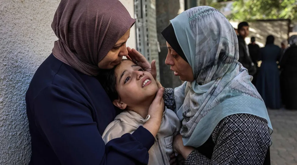 نساء يواسين ابنة ناشط في «حماس» بعد مقتله وزوجته في غارة إسرائيلية استهدفت مبنى سكنياً في مدينة غزة الثلاثاء (أ.ف.ب)