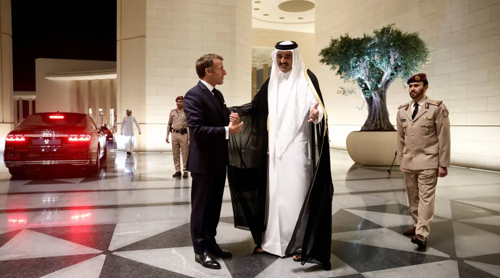أمير قطر الشيخ تميم بن حمد مستقبلاً الرئيس الفرنسي إيمانويل ماكرون في قصر لوسيل الثلاثاء (رويترز)