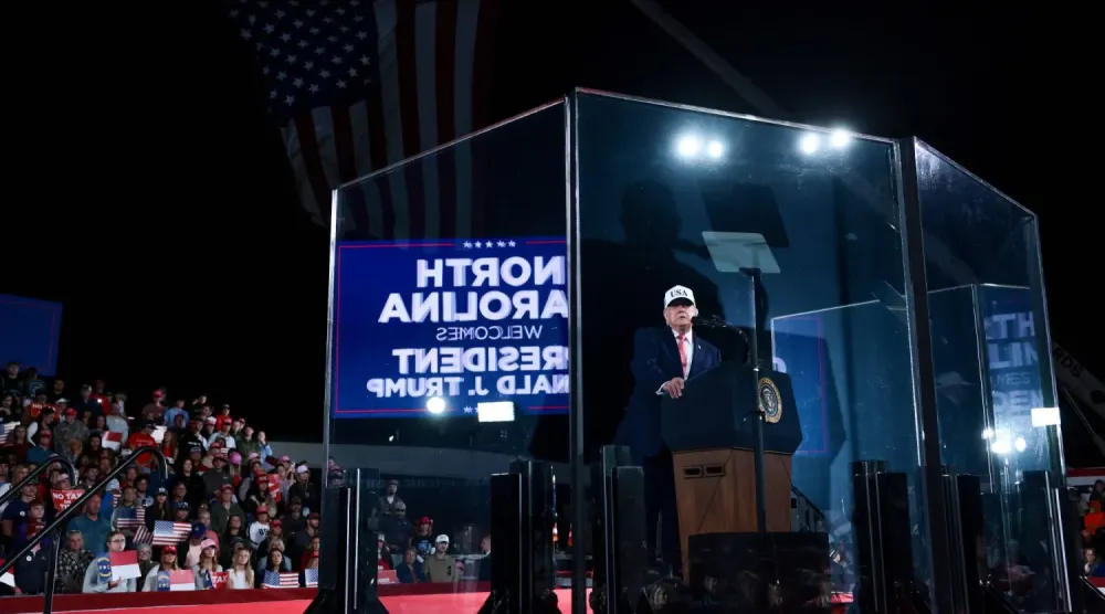 ABD Başkanı Donald Trump, 20 Ekim 2026'da Kuzey Carolina, Greenville'deki bir seçim mitinginde kurşun geçirmez camın arkasından yaptığı konuşmadan bir kare (AFP)
