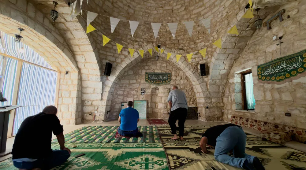 مواطنون يؤدون الصلاة في جامع ببلدة زوطر الغربية في جنوب لبنان (أ.ب)