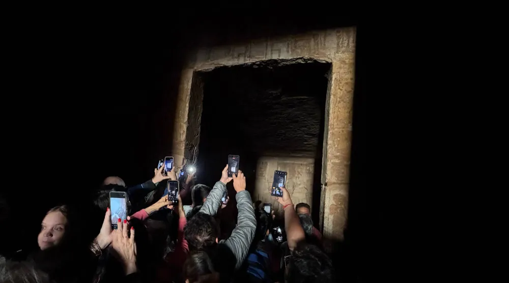  Tourists crowd to film the sun as it sends a beam of light into the Great Temple of Ramses II's dark inner chamber in Abu Simbel, 870 kilometers (540 miles) south of Cairo, Egypt, Thursday, Oct. 22, 2026, a rare 3,200-year-old astronomical ceremony that happens twice a year. (AP) 