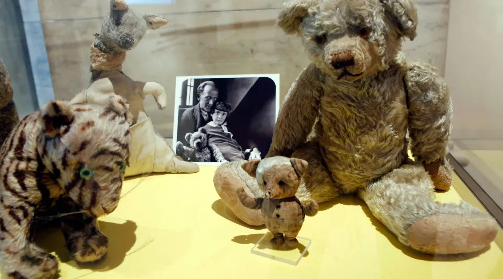 FILE - A photograph of author A. A. Milne with his son Christopher Robin is displayed beside Milne's son Christopher Robin's beloved teddy bear, the inspiration for "Winne-the-Pooh," at the New York Public Library, Monday, Sept. 30, 2013, in New York. (AP Photo/Kathy Willens,File)