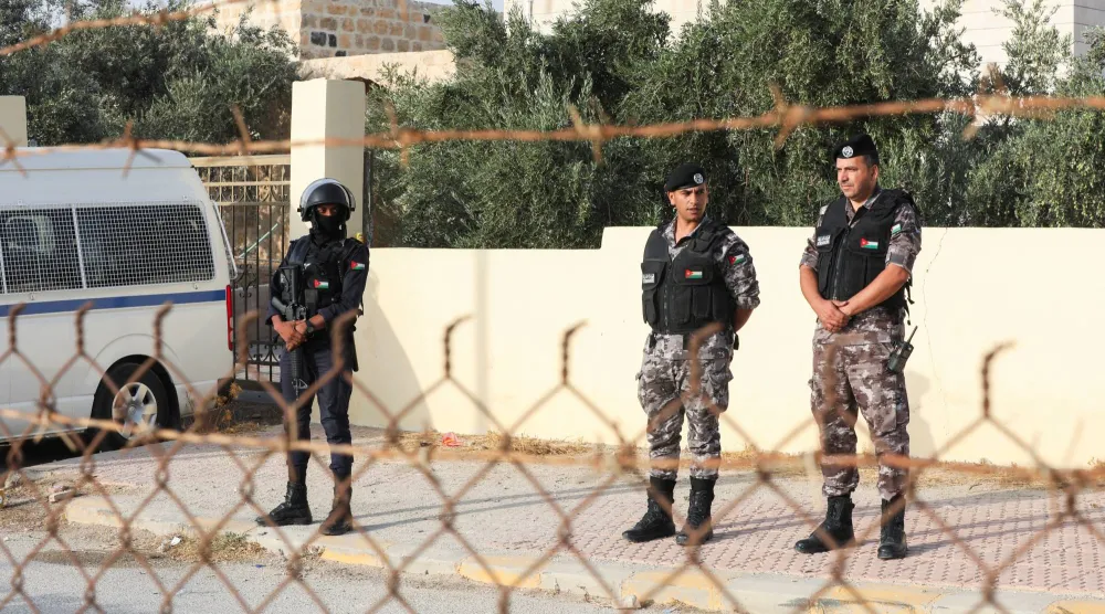 عناصر أمن يقفون خارج كنيسة القديس جاورجيوس للروم الأرثوذكس حيث أطلق مسلحون النار خلال مراسم جنازة في اليوم السابق بقرية حمود بمحافظة الكرك - الأردن (رويترز)