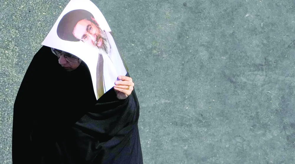 إيرانية تحمل صورة المرشد مجتبى خامنئي خلال مراسم الأربعين في طهران (أ.ب)