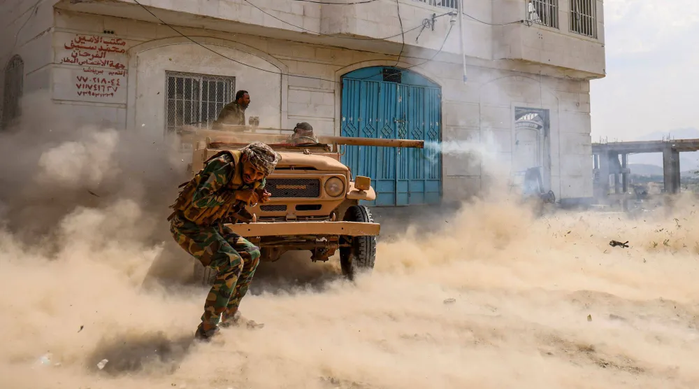 مقاتلون من الحكومة اليمنية في تعز يطلقون قذائف من مدفع مثبَّت على شاحنة نحو المواقع الحوثية (أ.ف.ب)
