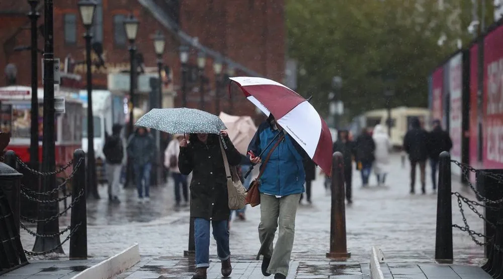 People walk through heavy rain in Liverpool, Britain, 24 October 2026. (EPA)
