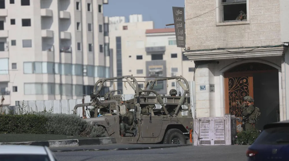 آليات عسكرية إسرائيلية وجنود ينتشرون على طول الشوارع في مدينة الخليل بالضفة الغربية المحتلة الأحد (د.ب.أ)