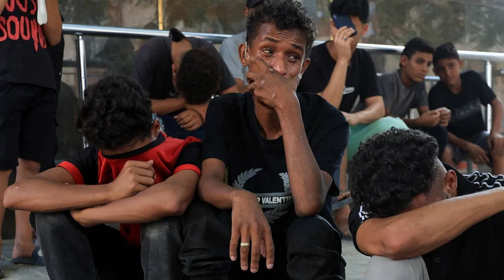 مشيعون خلال جنازة 3 فلسطينيين قُتلوا في غارة إسرائيلية في مستشفى الشفاء بمدينة غزة الأحد (رويترز)