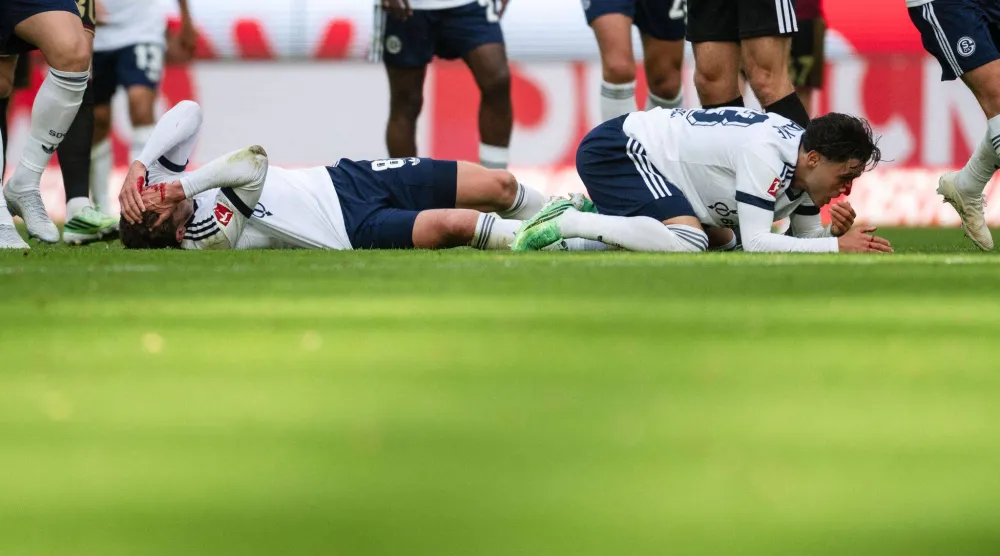 المغربي سفيان الفوزي لاعب فريق شالكه وزميله روبن غوسينس عقب إصابتهما في مواجهة كولن (د.ب.أ)