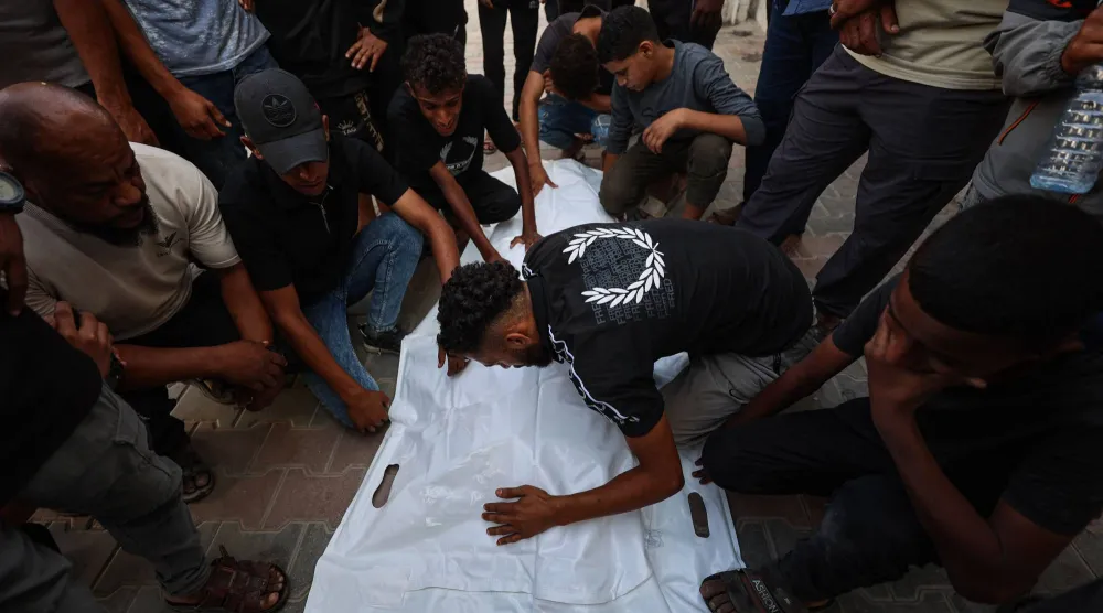 مشيّعون خلال جنازة 3 فلسطينيين قُتلوا بغارة إسرائيلية في مستشفى الشفاء بمدينة غزة (أ.ف.ب)