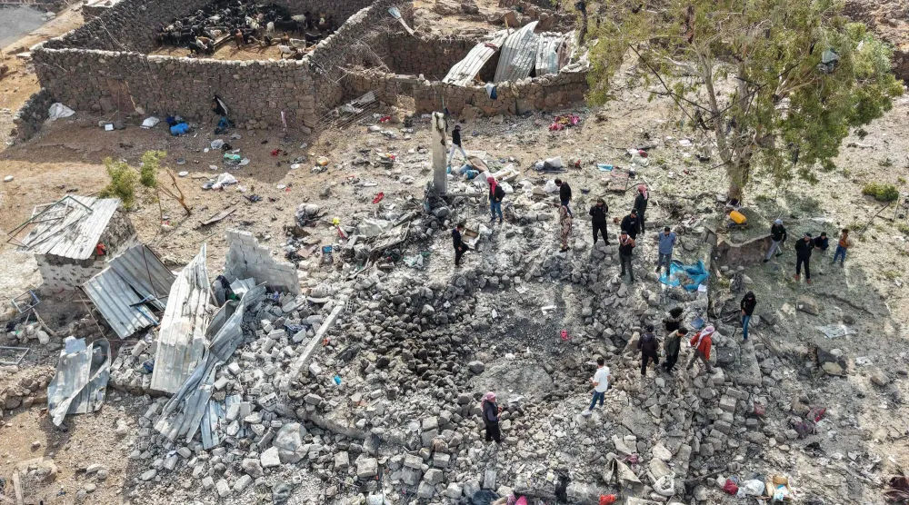 لقطة من أعلى لأشخاص يتفقدون الأضرار بموقع تعرَّض لغارات جوية شنتها الأردن في الليلة السابقة على قرية «الطاف» بمنطقة اللجاة في ريف درعا الشمالي الشرقي (أ.ف.ب)